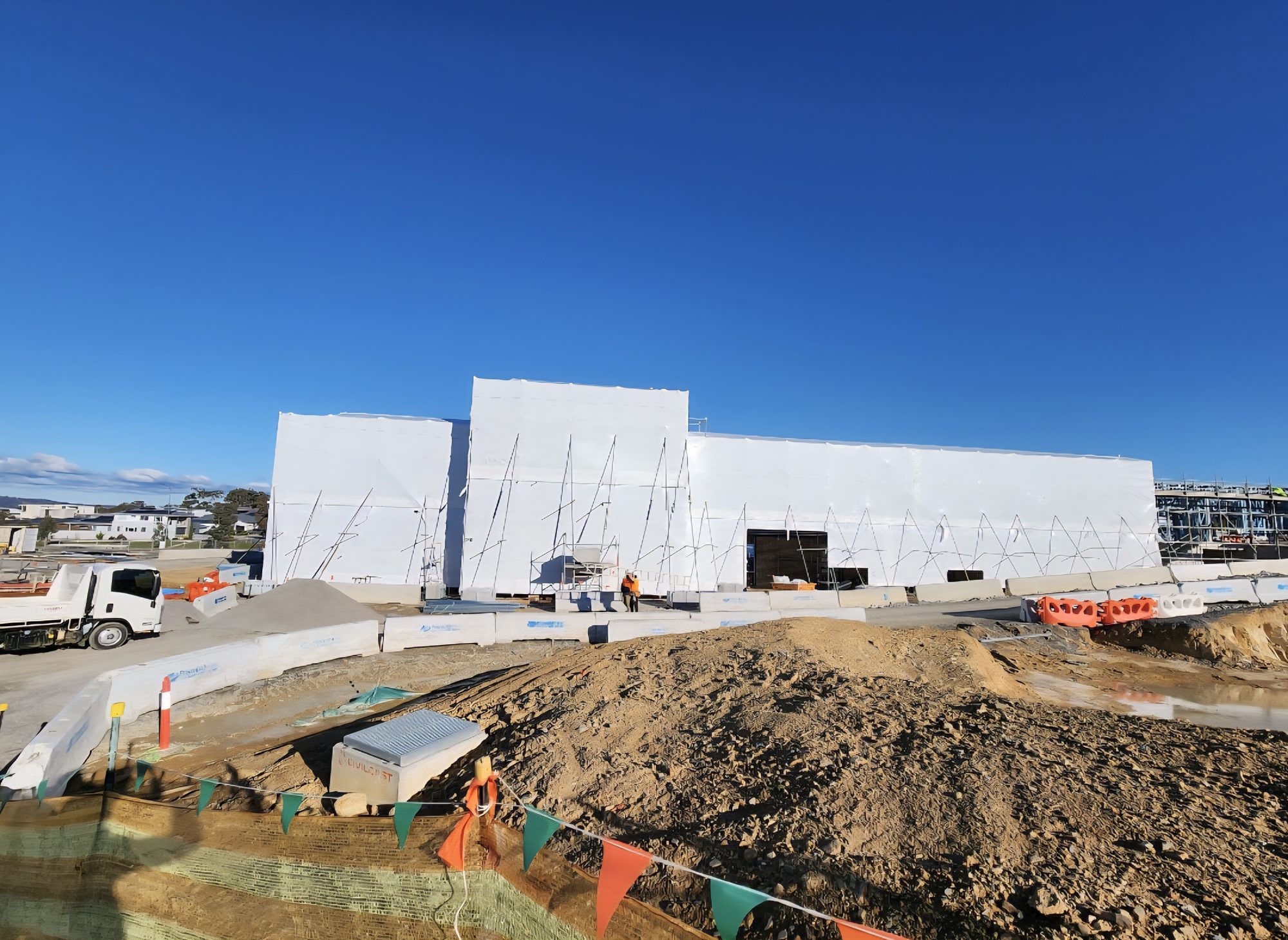Full building encapsulation protecting an exposed structure on a construction site
