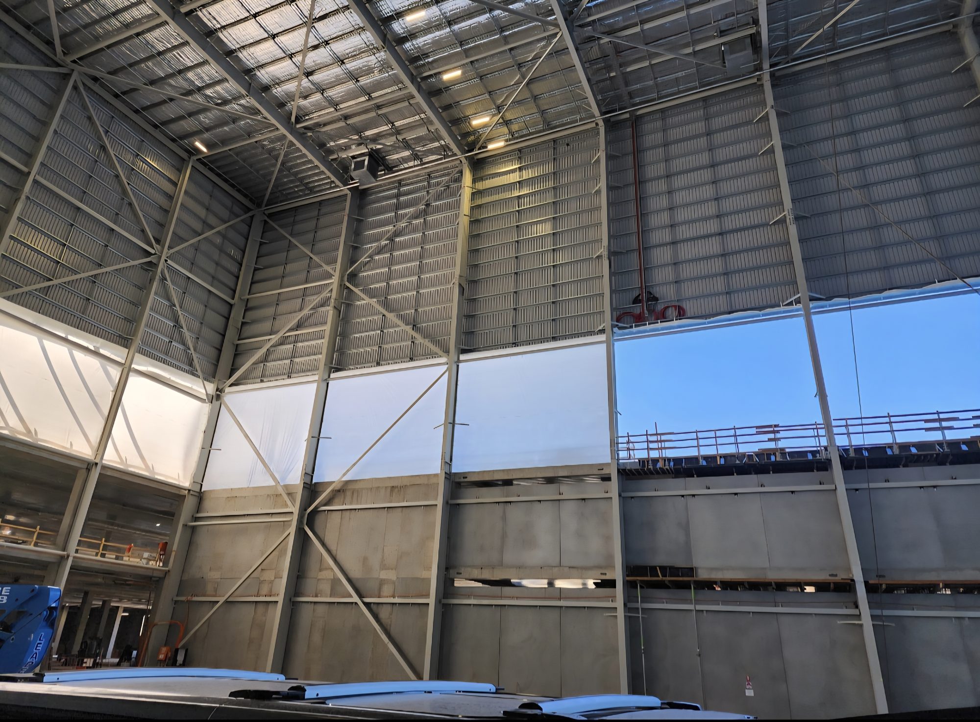 Containment installed to the open upper elevations of a high bay structure