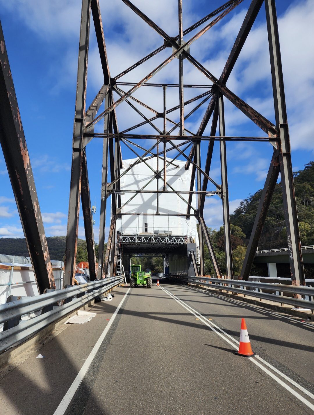 Containment enclosure viewed along the bridge deck through the steel truss portal